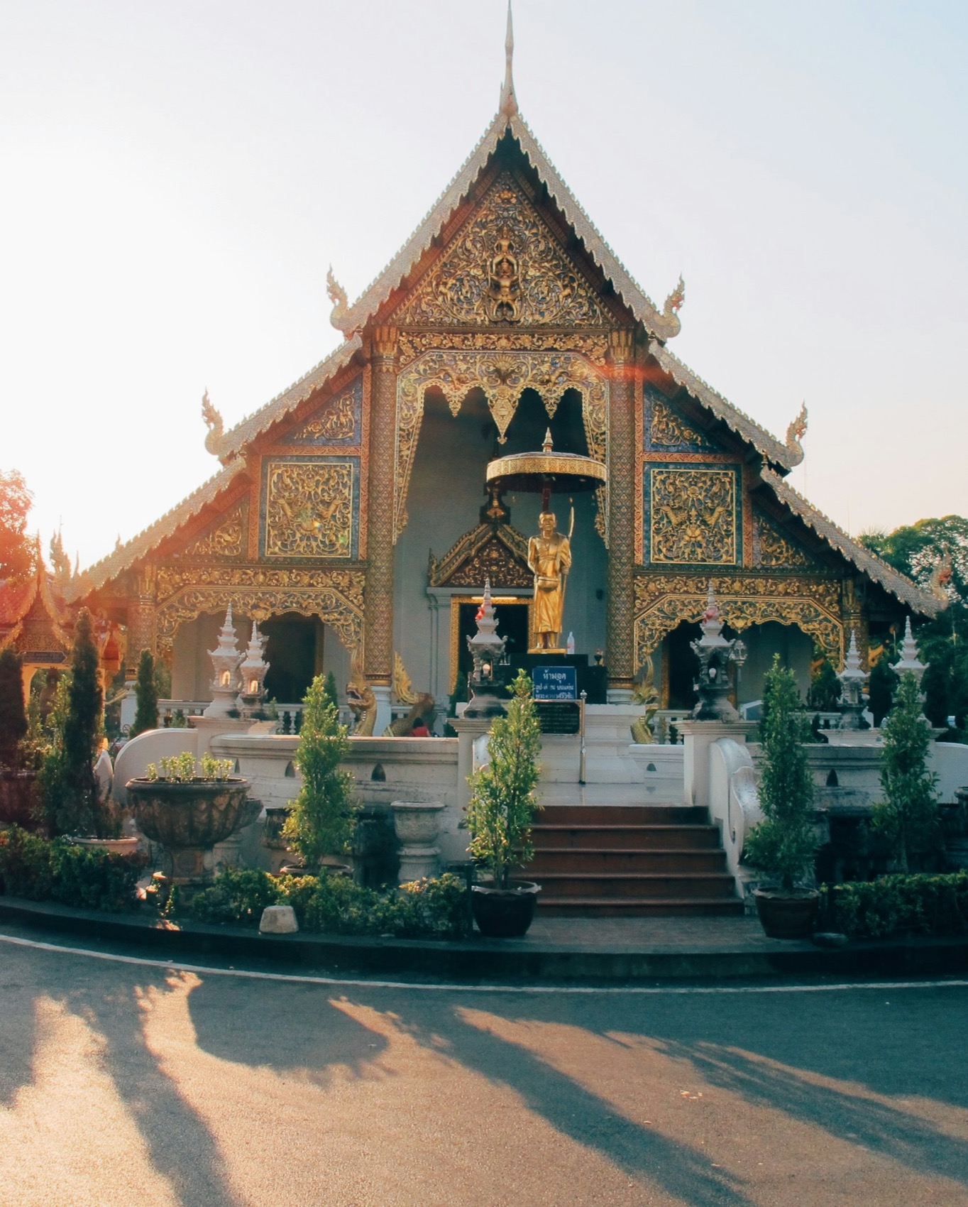 A golden-hour Lanna temple in Chiang Mai with carved teak gables